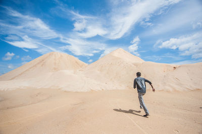 Rear view of man walking in desert