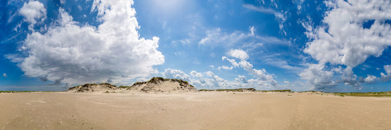 Scenic view of beach against cloudy sky