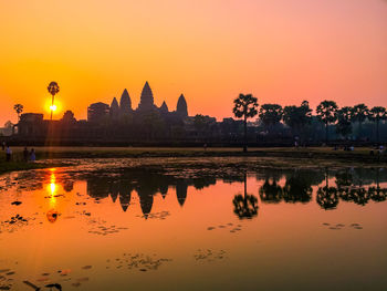 Reflection of buildings in lake during sunset