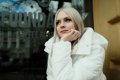 Portrait of blonde woman looking at camera outdoors 