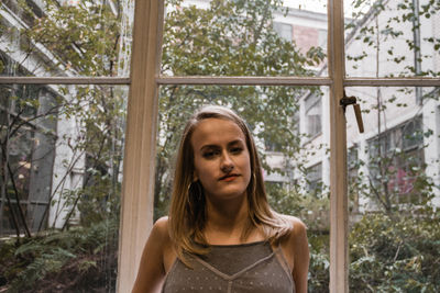 Young woman standing against window