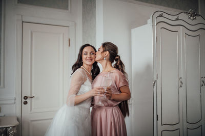 Happy woman standing against door