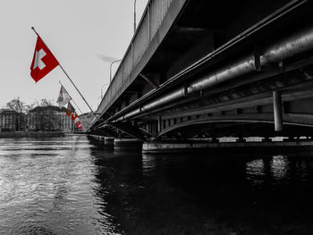 Bridge over river in city against sky