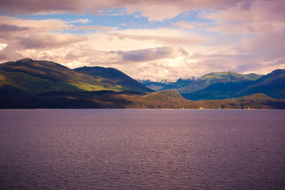 Scenic view of lake by mountains against sky