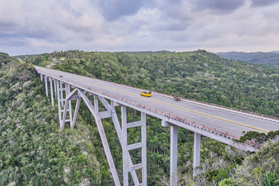 The highest of cuba bacunayagua bridge. automobile and horse-drawn transport moving along bridge.