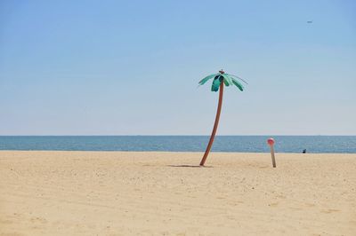 Scenic view of beach against clear blue sky