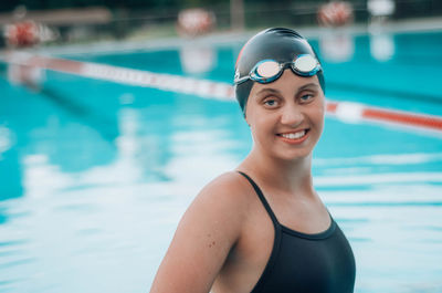 Portrait of smiling young woman swimming in pool