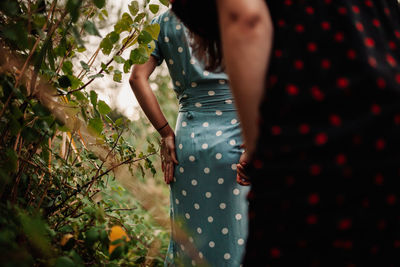 Rear view of women standing by plants