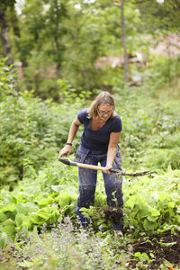 Mature woman digging in garden