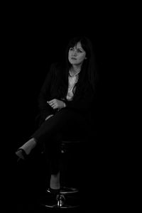 Portrait of a beautiful young woman over black background