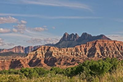 Rock formations on landscape against cloudy sky