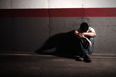 Man sitting on floor in city