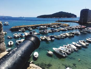 Boats moored in sea against clear sky