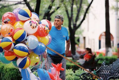 Full length of man with multi colored balloons