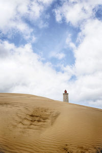 Lighthouse on desert against sky