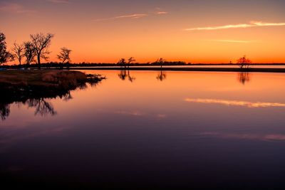 Scenic view of lake against orange sky