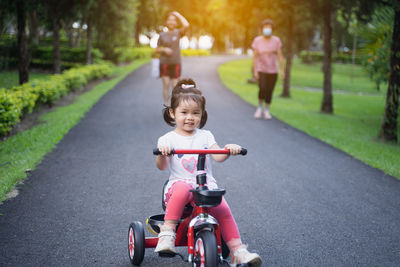 Portrait of cute girl riding bicycle on road