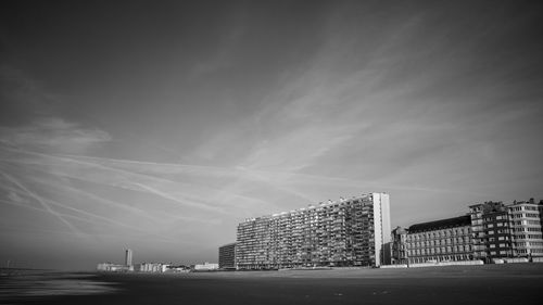 Modern buildings by sea against sky