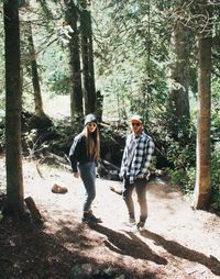 Friends standing on ground in forest