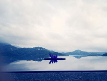 Boats in sea with mountain range in background