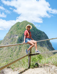 Full length of young woman standing on railing