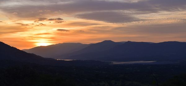 Scenic view of silhouette mountains against sky during sunset