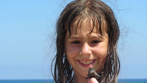 Portrait of smiling girl against sky