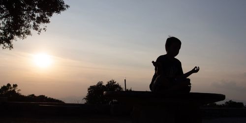 Silhouette statue against sky during sunset