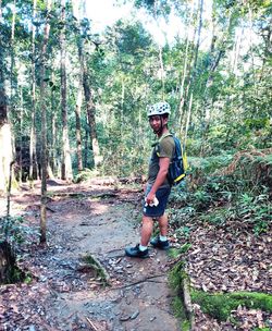 Man standing by plants in forest