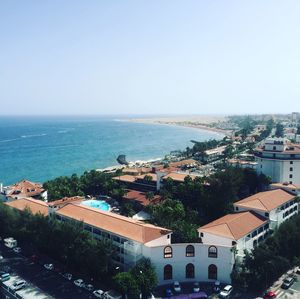 High angle view of town by sea against clear sky