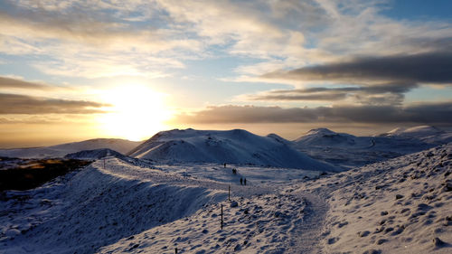 Scenic view of snowcapped mountains against sky during sunset