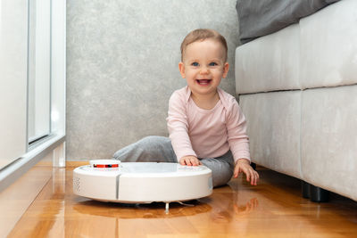 Portrait of cute baby boy sitting on bed at home