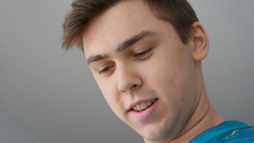 Low angle view of thoughtful young man against ceiling