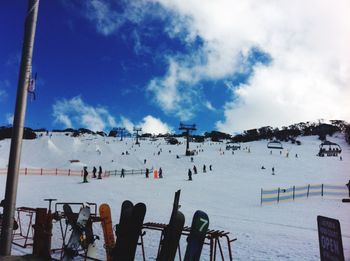 People enjoying on snowcapped mountain against sky
