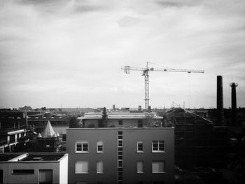 Silhouette of buildings against cloudy sky