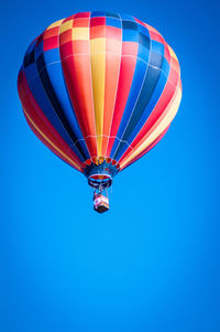 Low angle view of hot air balloon against clear blue sky