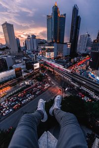 High angle view of person sitting on building terrace against cityscape at night