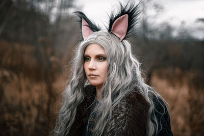 Close-up of young woman wearing costume standing against trees