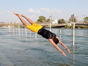 Full length of young man jumping in river