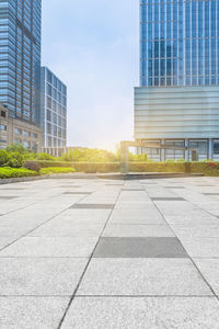 Road by buildings against sky in city