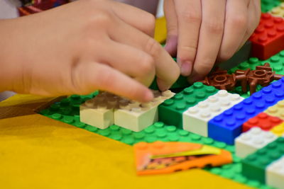 Cropped hands playing with colorful toy blocks