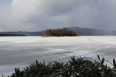 Scenic view of lake against sky during winter