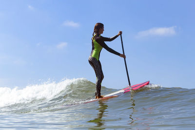 Female sup surfer on a wave