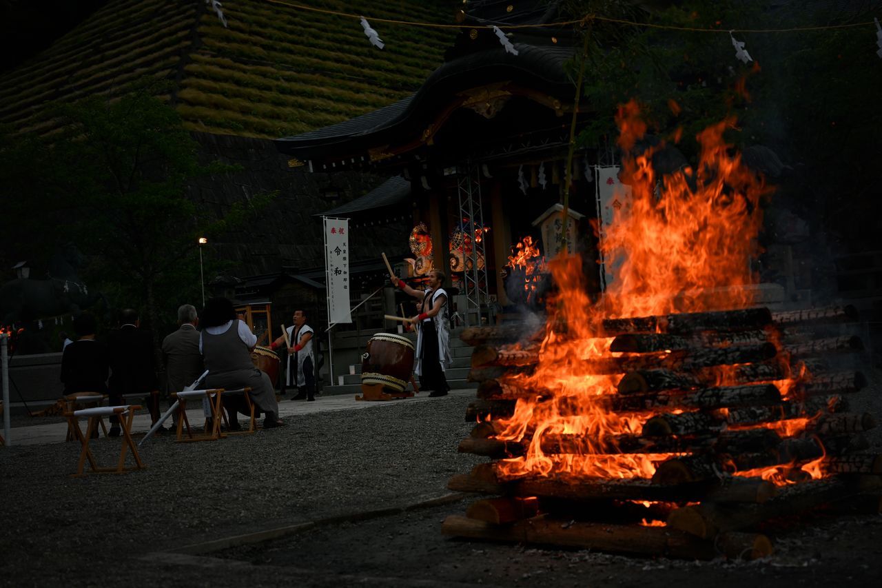 burning, heat - temperature, flame, group of people, real people, nature, architecture, built structure, fire, fire - natural phenomenon, religion, belief, outdoors, building exterior, men, people, building, spirituality, tree, place of worship