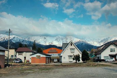 Houses by buildings against sky during winter