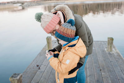 Mom looking at pictures on a camera with her son outside in winter