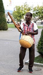 Full length of man playing music instrument on street