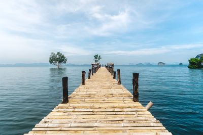 Wooden pier over sea against sky