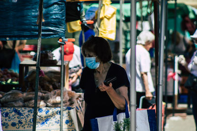 Rear view of woman standing at market stall