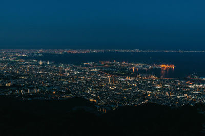 High angle view of illuminated city against sky at night